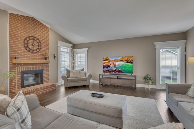 9606 Ireland Ct, Powell, OH 43065 - living area featuring wood finished floors, a fireplace, plenty of natural light, and vaulted ceiling