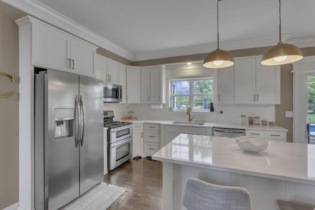 9606 Ireland Ct, Powell, OH 43065 - kitchen with stainless steel appliances, ornamental molding, plenty of natural light, backsplash, and dark wood-type flooring