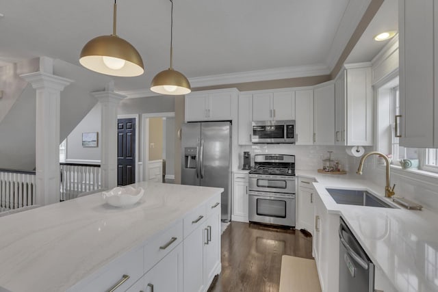 9606 Ireland Ct, Powell, OH 43065 - kitchen with stainless steel appliances, light stone counters, tasteful backsplash, white cabinetry, and decorative light fixtures