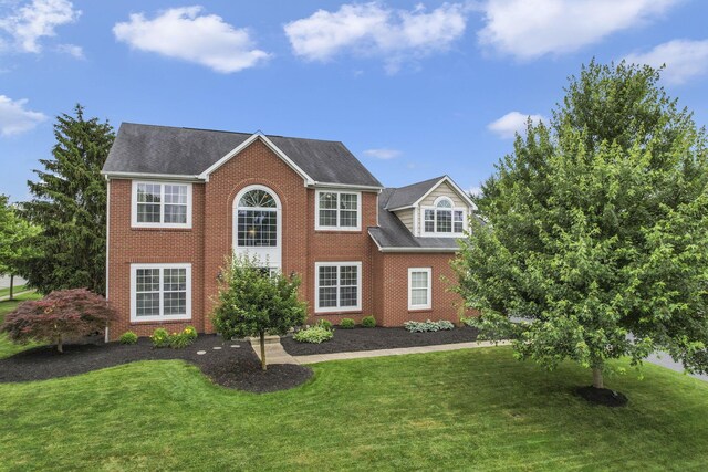 9606 Ireland Ct, Powell, OH 43065 - colonial house featuring a front lawn, brick siding, and a shingled roof