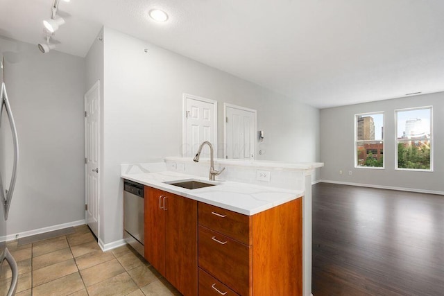 121 E Noble St Unit 3, Columbus, OH 43215 - kitchen with stainless steel dishwasher, a peninsula, brown cabinets, track lighting, and open floor plan