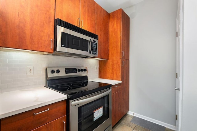 121 E Noble St Unit 3, Columbus, OH 43215 - kitchen with appliances with stainless steel finishes, brown cabinetry, backsplash, and light countertops