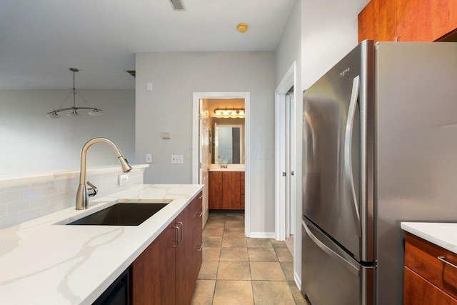 121 E Noble St Unit 3, Columbus, OH 43215 - kitchen featuring freestanding refrigerator, light stone counters, hanging light fixtures, light tile patterned floors, and decorative backsplash