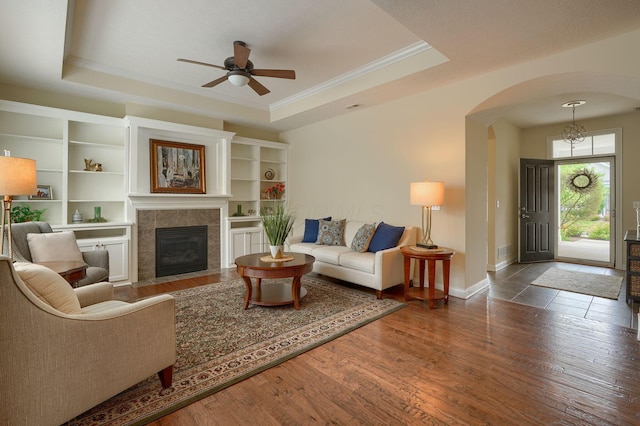 5428 Tathwell Dr, New Albany, OH 43054 - living area featuring arched walkways, a raised ceiling, a ceiling fan, wood finished floors, and ornamental molding