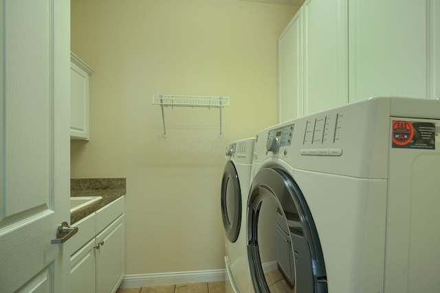 5428 Tathwell Dr, New Albany, OH 43054 - laundry room with washer and clothes dryer, cabinet space, and light tile patterned floors