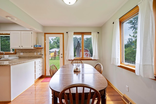 582 E Stanton Ave, Columbus, OH 43214 - dining space with healthy amount of natural light, light wood-style floors, and baseboard heating