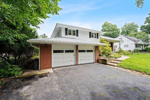 582 E Stanton Ave, Columbus, OH 43214 - view of front of property with brick siding, driveway, a front lawn, and a metal roof