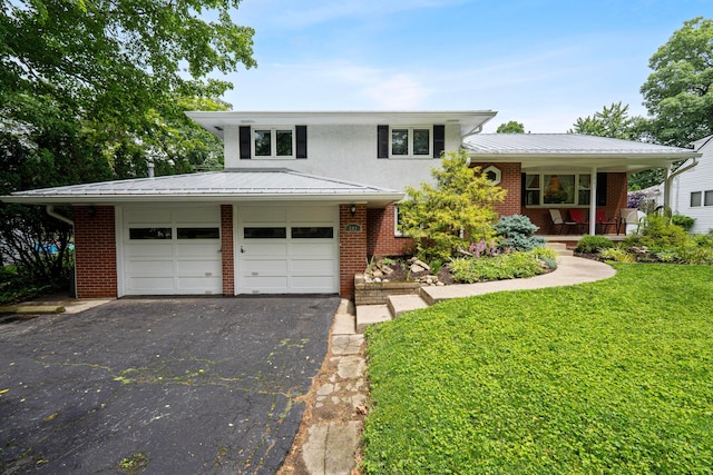 582 E Stanton Ave, Columbus, OH 43214 - split level home with brick siding, driveway, a front lawn, covered porch, and a metal roof