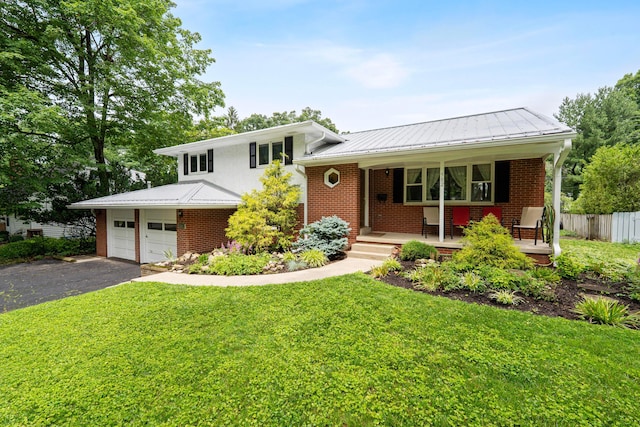 582 E Stanton Ave, Columbus, OH 43214 - tri-level home featuring covered porch, driveway, a metal roof, and brick siding