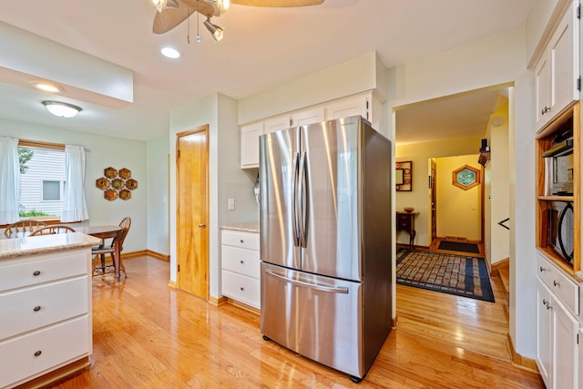 582 E Stanton Ave, Columbus, OH 43214 - kitchen featuring freestanding refrigerator, light wood-type flooring, white cabinetry, ceiling fan, and black microwave