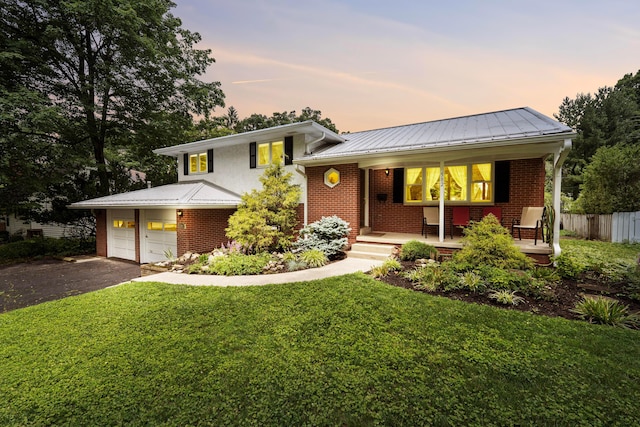 582 E Stanton Ave, Columbus, OH 43214 - tri-level home with covered porch, brick siding, driveway, and a metal roof