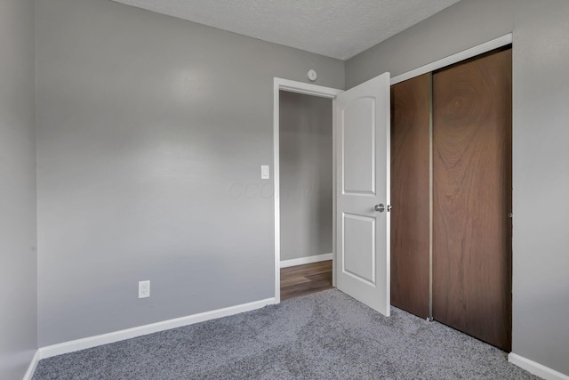2103 Rochelle Pl, Columbus, OH 43232 - unfurnished bedroom featuring carpet flooring, a closet, and a textured ceiling