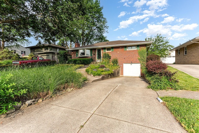 4453 Marland Dr, Columbus, OH 43224 - ranch-style home with concrete driveway, brick siding, a chimney, and an attached garage