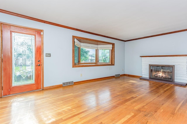 4453 Marland Dr, Columbus, OH 43224 - unfurnished living room featuring light wood-style flooring, ornamental molding, and a brick fireplace