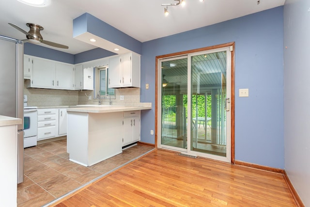 4453 Marland Dr, Columbus, OH 43224 - kitchen with white range with electric cooktop, light countertops, ceiling fan, white cabinetry, and a peninsula