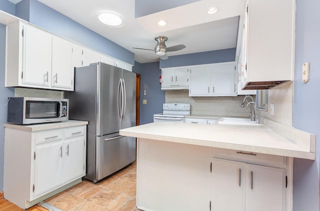 4453 Marland Dr, Columbus, OH 43224 - kitchen featuring stainless steel appliances, under cabinet range hood, a peninsula, a ceiling fan, and light countertops