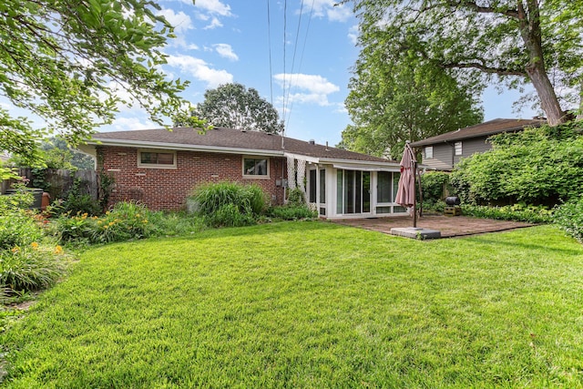 4453 Marland Dr, Columbus, OH 43224 - back of property featuring a sunroom, brick siding, and a patio area