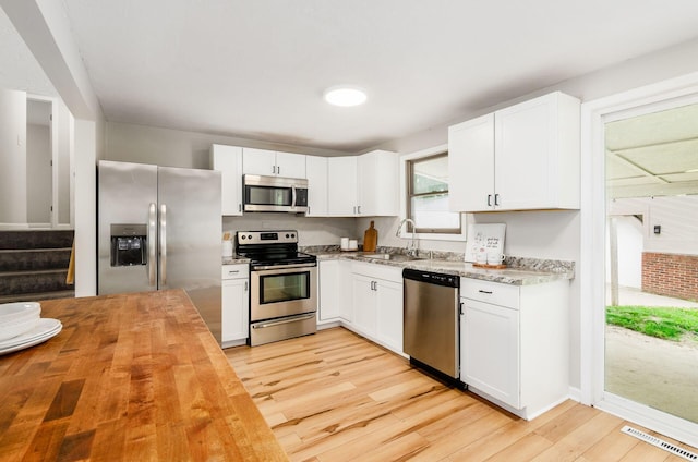 3623 Bolamo Dr, Westerville, OH 43081 - kitchen featuring appliances with stainless steel finishes, wood counters, light wood finished floors, and white cabinets