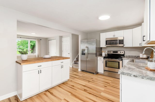 3623 Bolamo Dr, Westerville, OH 43081 - kitchen with stainless steel appliances, butcher block countertops, light wood-type flooring, and white cabinetry