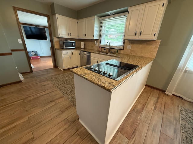 1819 Walnut Rd, Heath, OH 43056 - kitchen featuring stainless steel appliances, white cabinetry, light stone counters, and light wood-style floors