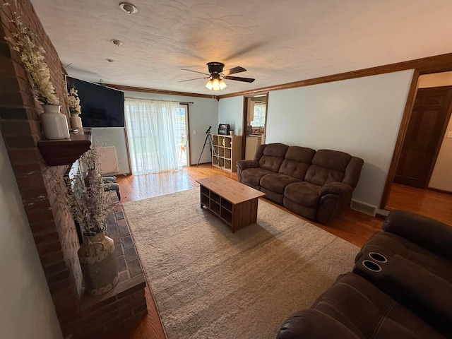 1819 Walnut Rd, Heath, OH 43056 - living room with wood finished floors, crown molding, a ceiling fan, and a fireplace