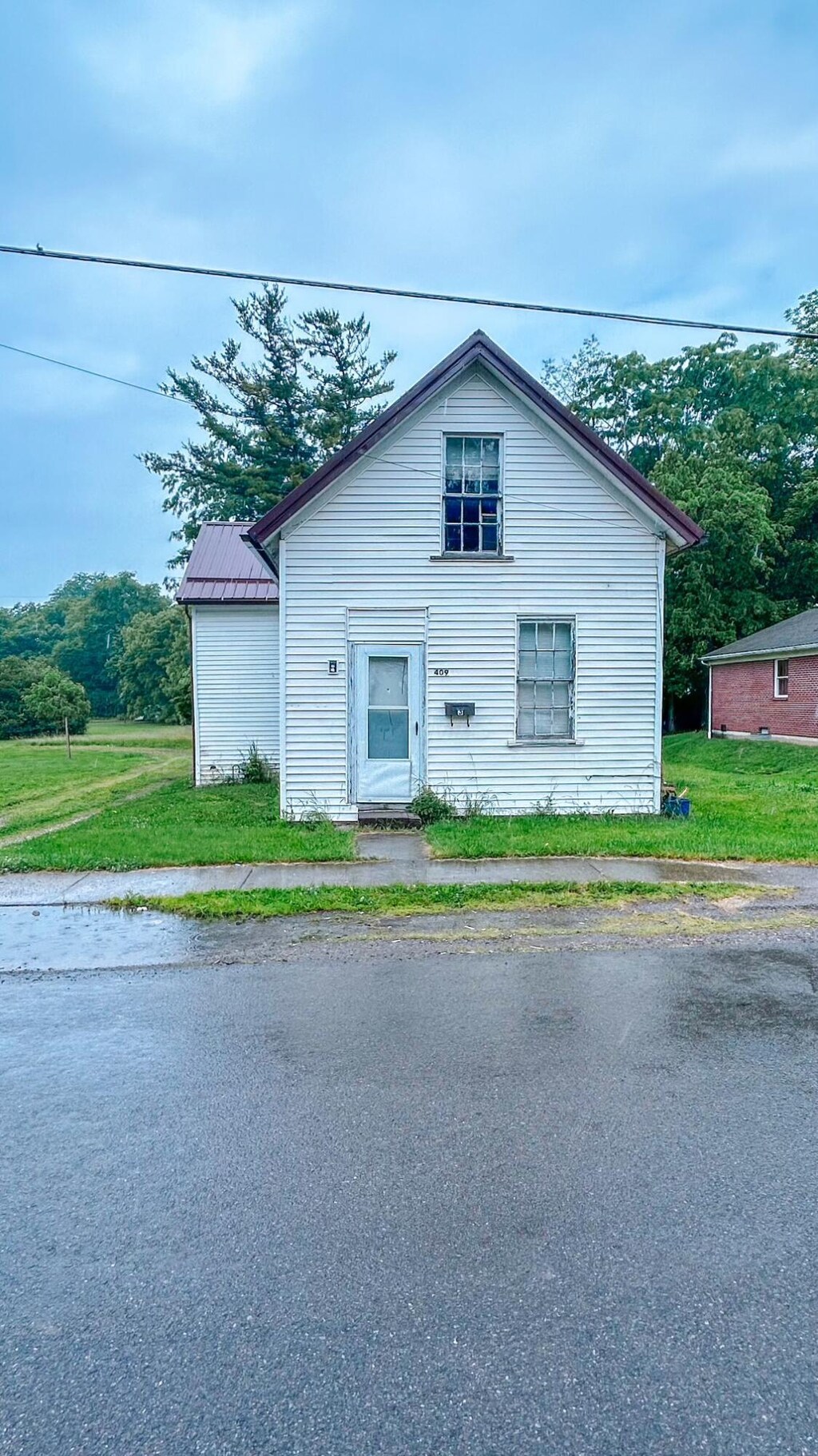 409 Lawrence St, Bellefontaine, OH 43311 - traditional home featuring a front lawn and a metal roof