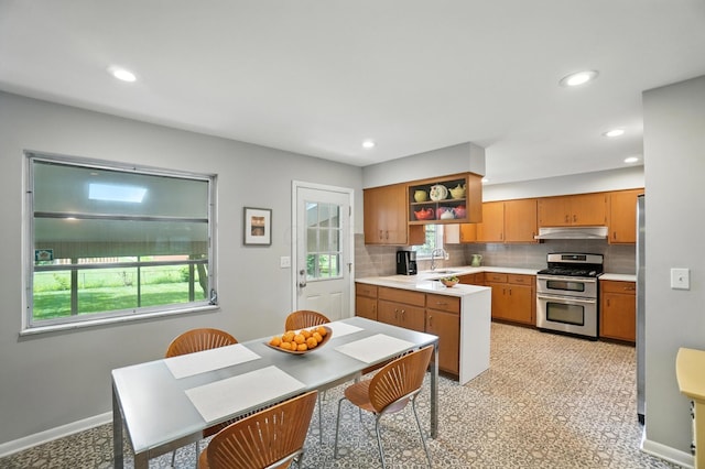 5445 Rockwood Rd, Columbus, OH 43229 - kitchen with double oven range, under cabinet range hood, light countertops, backsplash, and brown cabinets