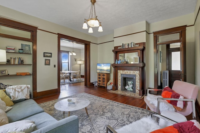 300 E Main St, Somerset, OH 43783 - living area with a chandelier, wood finished floors, radiator heating unit, and a tiled fireplace