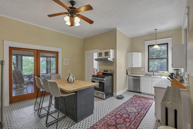300 E Main St, Somerset, OH 43783 - kitchen featuring stainless steel appliances, light floors, white cabinets, under cabinet range hood, and a kitchen breakfast bar