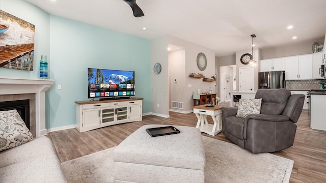 7087 Ribault Dr NW, Pickerington, OH 43147 - living room featuring wood finished floors, recessed lighting, a ceiling fan, and a fireplace