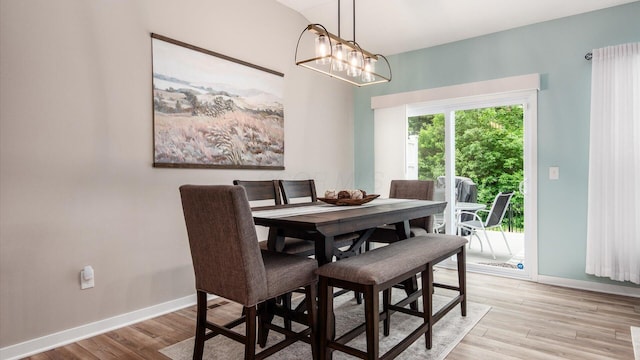 7087 Ribault Dr NW, Pickerington, OH 43147 - dining area with light wood-style flooring and a chandelier