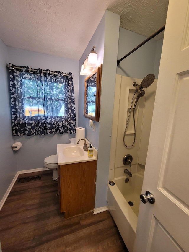 7358 Roshon Ave, Reynoldsburg, OH 43068 - bathroom with wood finished floors, a textured ceiling, vanity, and washtub / shower combination