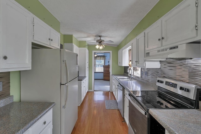 6605 Lancaster Rd SE, Hebron, OH 43025 - kitchen with appliances with stainless steel finishes, under cabinet range hood, white cabinets, light wood-style flooring, and a ceiling fan
