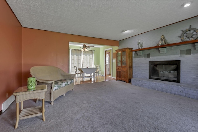 6605 Lancaster Rd SE, Hebron, OH 43025 - living room with carpet, a textured ceiling, a ceiling fan, and a fireplace