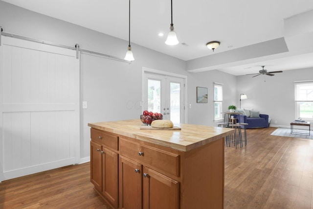 2635 Main St, Powell, OH 43065 - kitchen featuring butcher block counters, a barn door, dark wood finished floors, hanging light fixtures, and ceiling fan