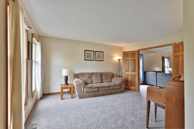 2885 Wynneleaf St, Hilliard, OH 43026 - living area with light carpet, a textured ceiling, and healthy amount of natural light