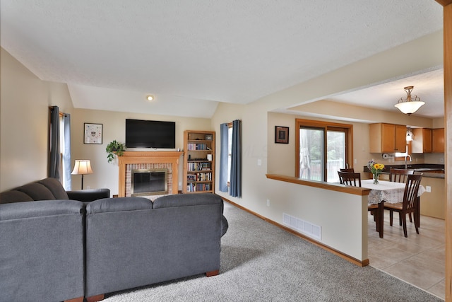 2885 Wynneleaf St, Hilliard, OH 43026 - living room featuring a brick fireplace, a textured ceiling, and light colored carpet
