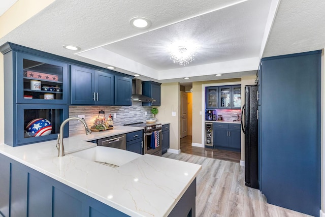 6651 Lancaster Rd, Hebron, OH 43025 - kitchen featuring appliances with stainless steel finishes, wall chimney exhaust hood, a peninsula, beverage cooler, and decorative backsplash