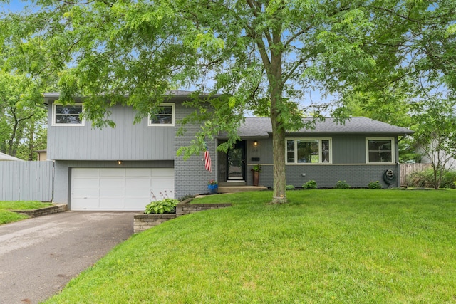 1838 Merriweather Dr, Columbus, OH 43221 - split level home featuring asphalt driveway, an attached garage, and brick siding