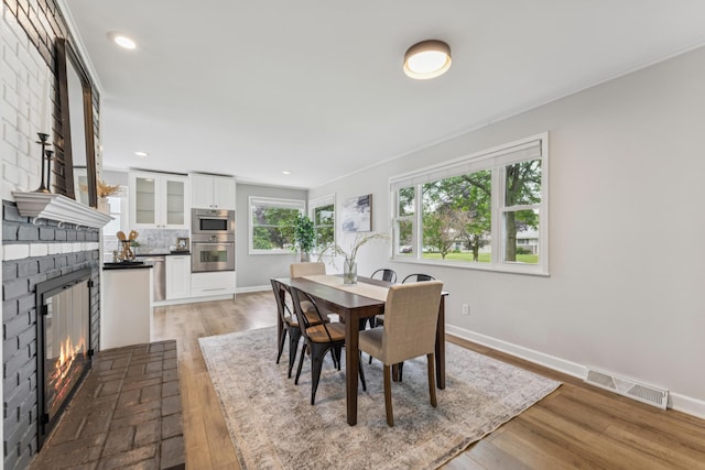 1838 Merriweather Dr, Columbus, OH 43221 - dining room with a fireplace, light wood-style flooring, recessed lighting, and crown molding