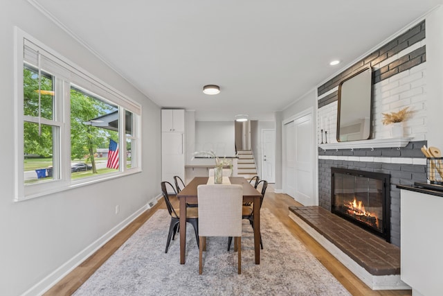 1838 Merriweather Dr, Columbus, OH 43221 - dining area with light wood-style flooring, a fireplace, crown molding, and recessed lighting