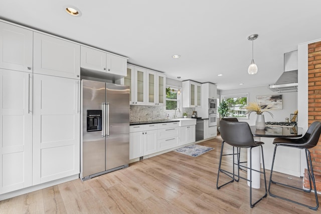 1838 Merriweather Dr, Columbus, OH 43221 - kitchen featuring appliances with stainless steel finishes, wall chimney range hood, light wood-type flooring, backsplash, and recessed lighting