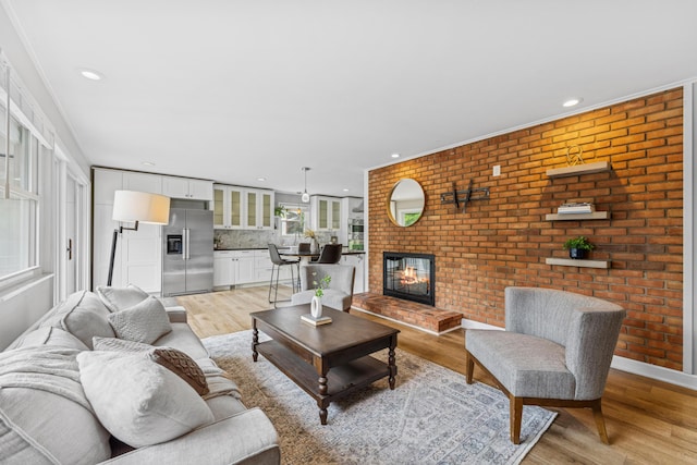 1838 Merriweather Dr, Columbus, OH 43221 - living room with light wood-style flooring, recessed lighting, a brick fireplace, ornamental molding, and brick wall