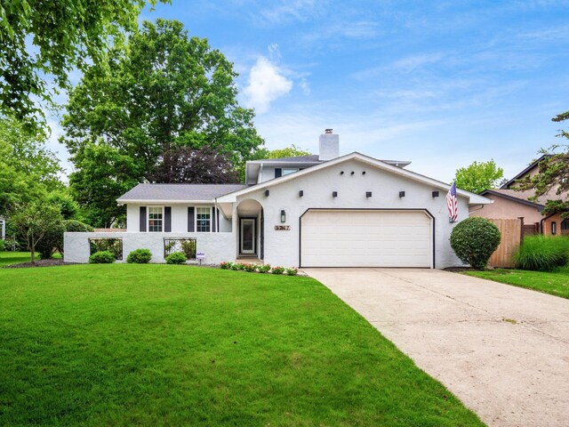 5247 Heathmoor St, Columbus, OH 43235 - view of front of house featuring an attached garage, driveway, a chimney, and stucco siding