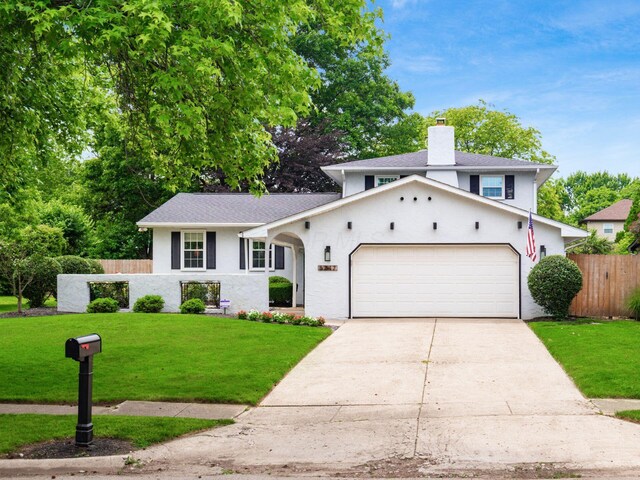 5247 Heathmoor St, Columbus, OH 43235 - split level home featuring a chimney, a garage, concrete driveway, stucco siding, and roof with shingles