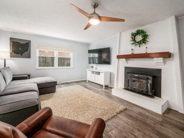 5247 Heathmoor St, Columbus, OH 43235 - living area featuring a ceiling fan, wood finished floors, a textured ceiling, and a wood stove