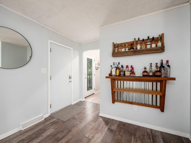5247 Heathmoor St, Columbus, OH 43235 - entryway with crown molding, a bar, wood finished floors, and a textured ceiling