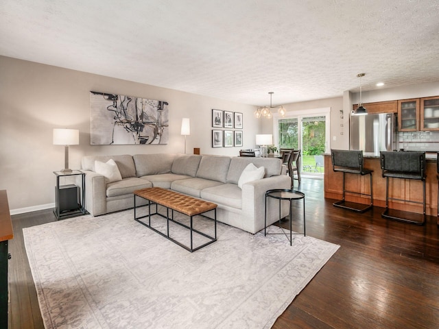 5247 Heathmoor St, Columbus, OH 43235 - living room featuring a chandelier, dark wood finished floors, and a textured ceiling