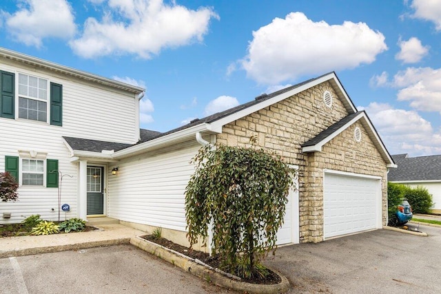 4635 Shalers Dr Unit 44D, Columbus, OH 43228 - traditional home featuring a garage, driveway, and stone siding