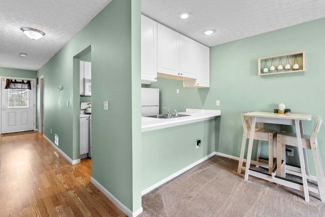 4635 Shalers Dr Unit 44D, Columbus, OH 43228 - laundry area featuring a textured ceiling, wood finished floors, recessed lighting, and cabinet space
